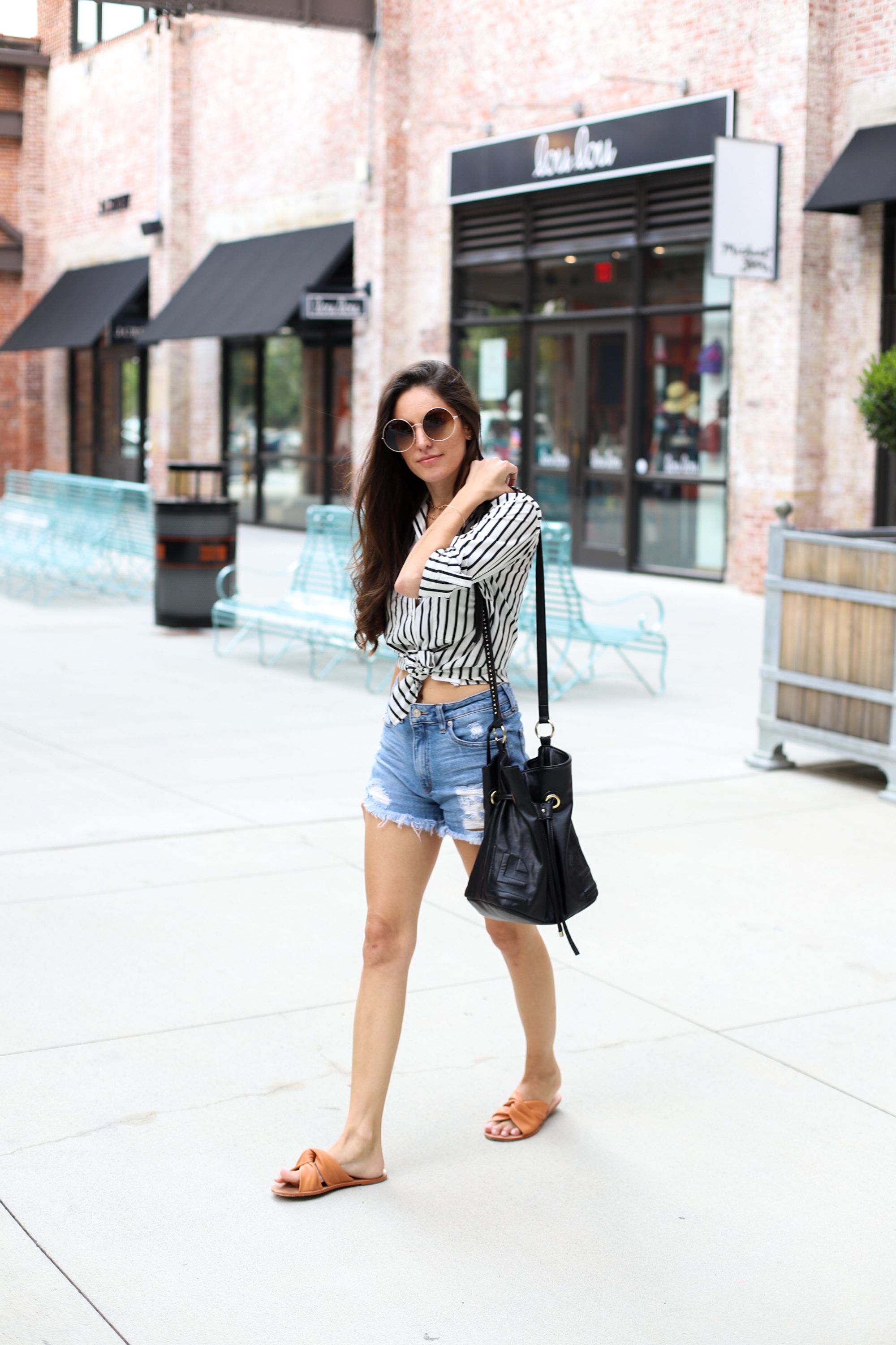 striped button down, how to wear a button down with cutoffs, stripes in summer, summer stripes, summer city style, urban style, summer outfit ideas, casual summer style, kaanas Belem Orange, round sunglasses, black bucket bag