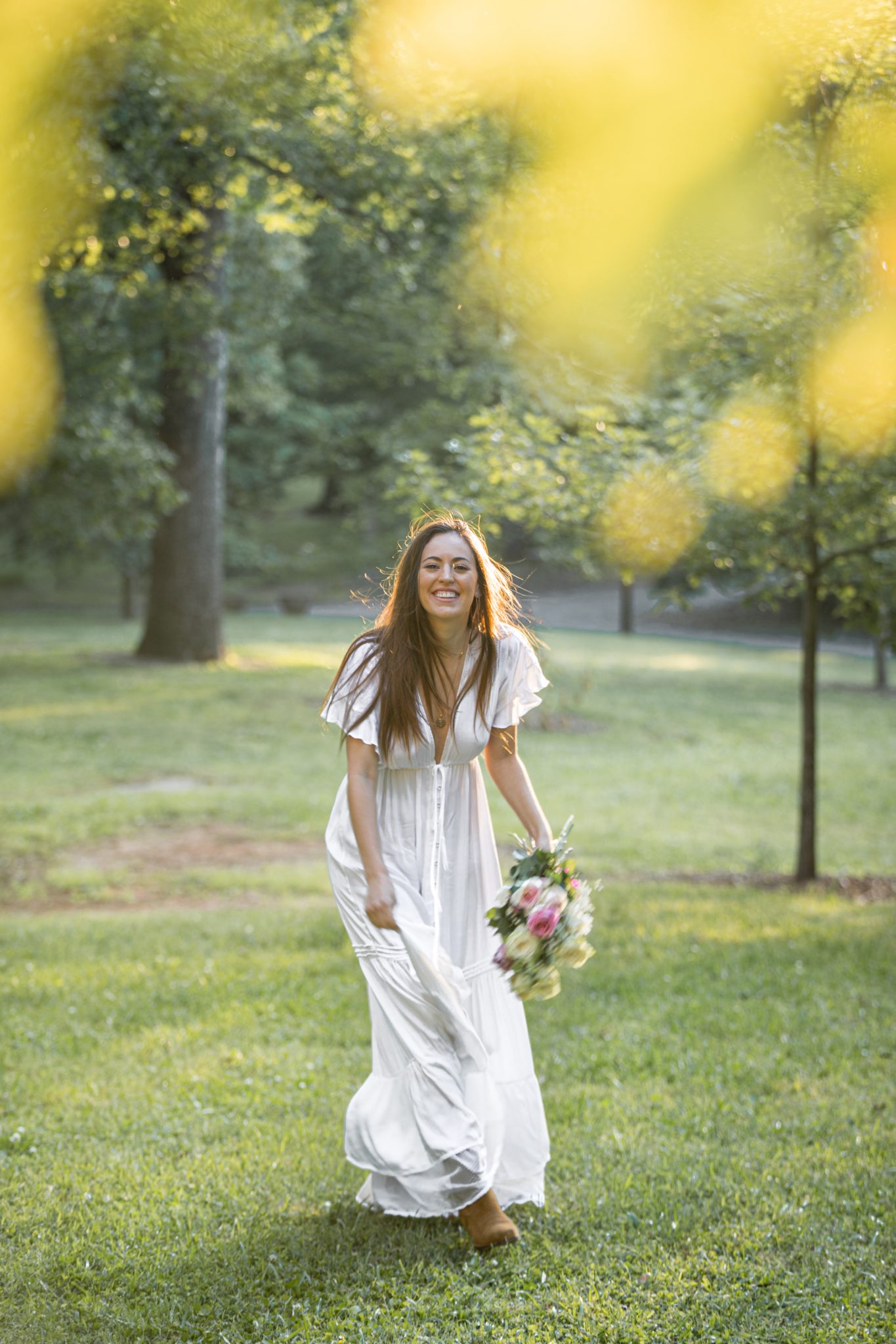 woman holding flowers in a park smiling 